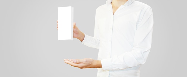 Uomo in camicia bianca che tiene opuscolo in bianco nella mano