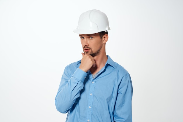 Uomo in camicia blu protezione casco da costruzione bianco ingegnere professionista Foto di alta qualità