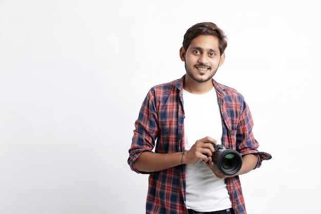 Uomo in camicia che tiene una macchina fotografica professionale