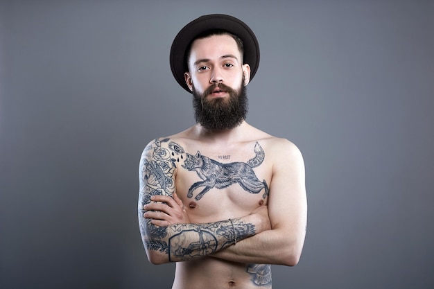 Uomo in cappello Ragazzo hipster con corpo tatuato