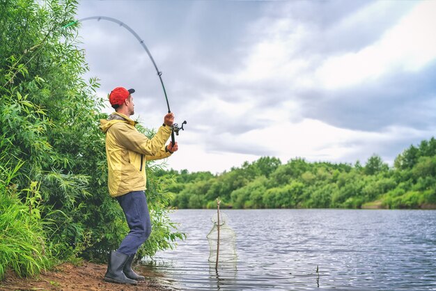 Uomo in cappotto che pesca in un lago