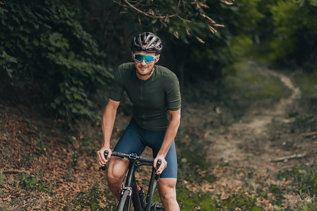 Uomo in casco e occhiali in sella a una bici all'aria aperta