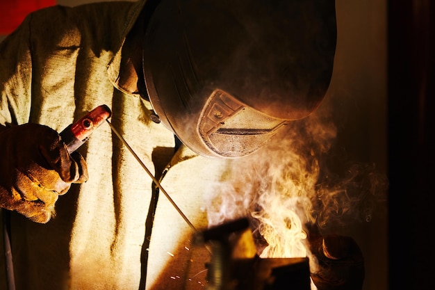 Uomo in costruzione metallica di saldatura maschera protettiva