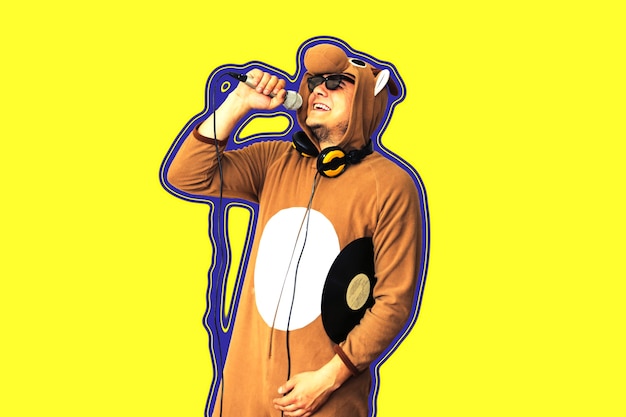 Uomo in costume cosplay di una mucca che canta al karaoke. Ragazzo nel pigiama animale divertente che tiene il microfono degli indumenti da notte. Foto divertente. Idee per feste. Musica da discoteca.