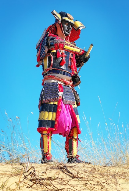 Uomo in costume da samurai con spada. Personaggio originale