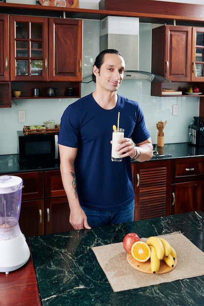 Uomo in forma con un bicchiere di cocktail proteico