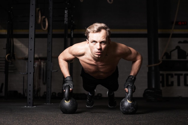 Uomo in forma in palestra che fa flessioni