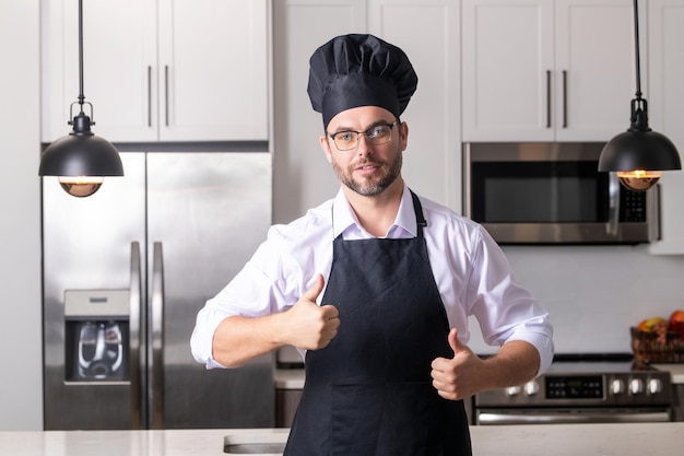 Uomo in grembiule da chef che cucina in cucina