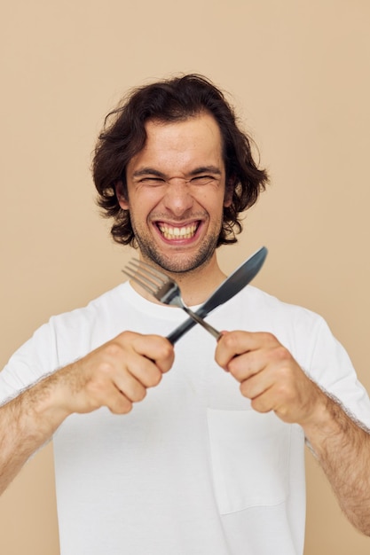 Uomo in maglietta bianca con coltello con forchetta Stile di vita inalterato