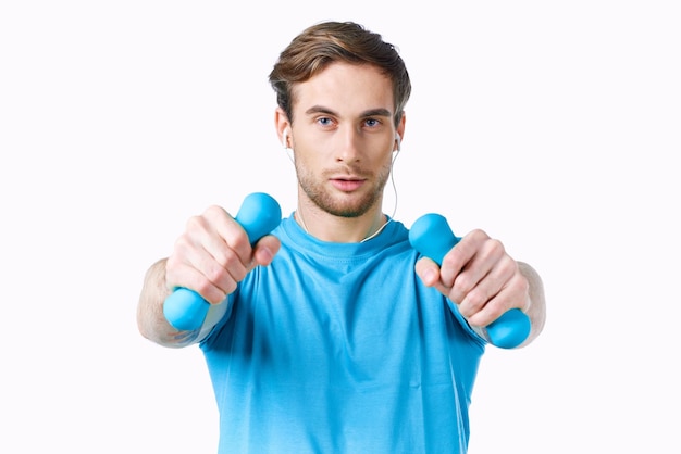 Uomo in maglietta blu da manubri in forma fisica delle mani