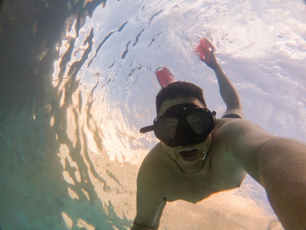 Uomo in maschera da snorkeling selfie vacanze estive al mare