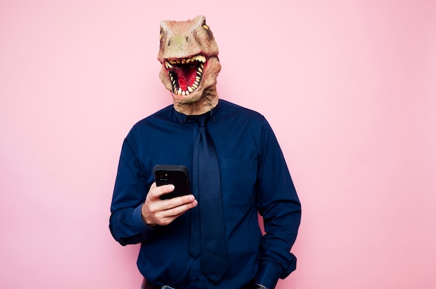 Uomo in maschera di dinosauro che utilizza smartphone