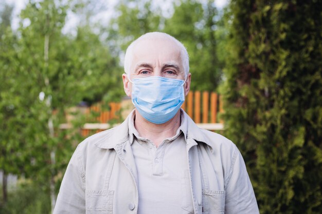 Uomo in maschera medica nel parco. Protezione dalla malattia. Concetto di sicurezza sanitaria