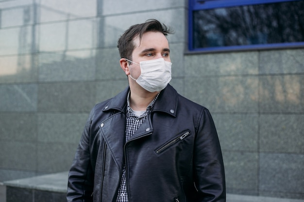 Uomo in maschera medica sulla strada. Protezione dalla malattia. Concetto di sicurezza sanitaria