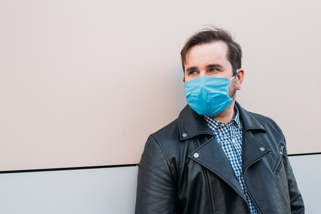 Uomo in maschera protettiva. Uomo malato con la maschera da portare di influenza, concetto di influenza epidemica sulla via.