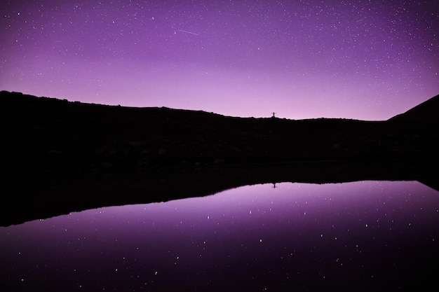 Uomo in montagna al cielo stellato