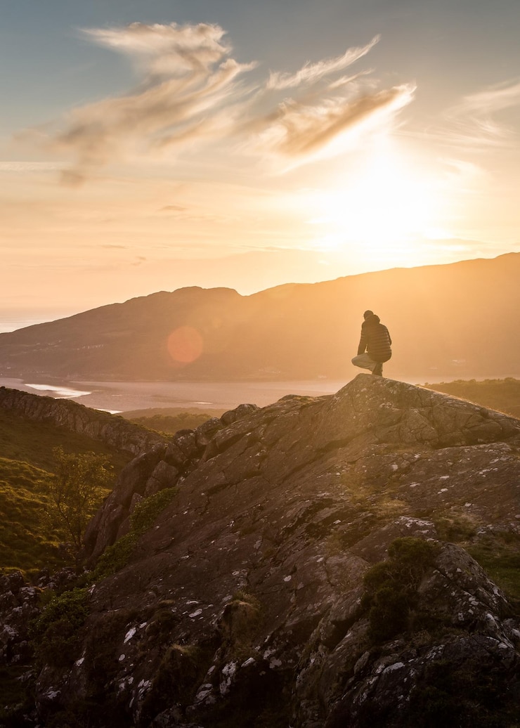 Foto uomo in montagna contro il cielo durante il tramonto