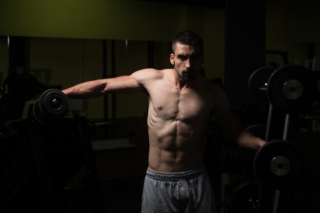 Uomo In Palestra Che Esercita La Spalla Con Il Manubrio