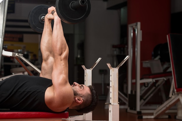 Uomo In Palestra Che Esercitano I Tricipiti Con Il Bilanciere