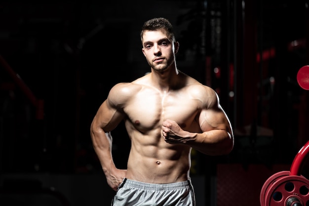 Uomo In Palestra Che Mostra Il Suo Corpo Ben Allenato