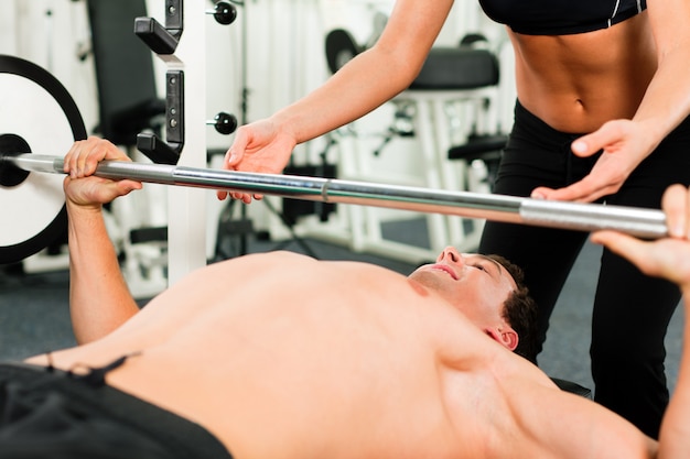 Uomo in palestra che si esercita con bilanciere