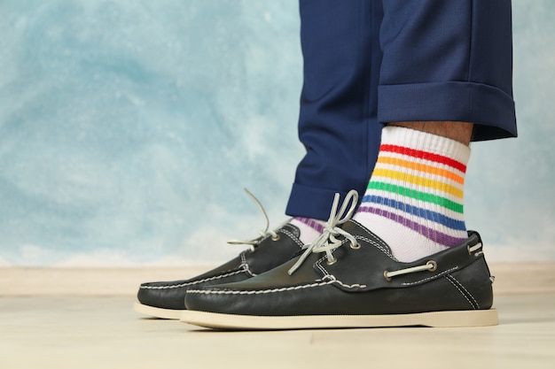 Uomo in pantaloni blu, mocassini e calzini LGBT