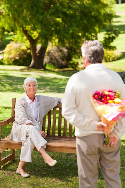 Uomo in pensione che offre fiori a sua moglie