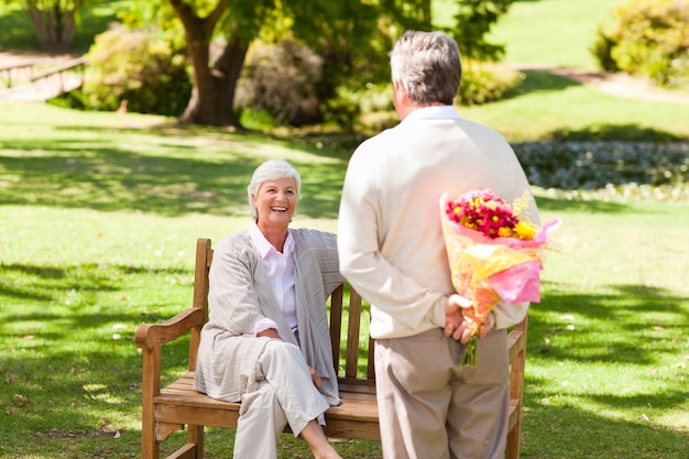 Uomo in pensione che offre fiori a sua moglie