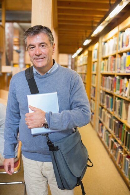 Uomo in piedi accanto a scaffali in una libreria