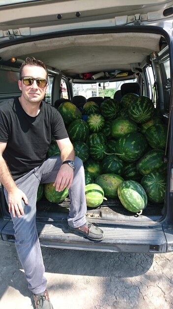 Uomo in piedi accanto a un pick-up con meloni d'acqua