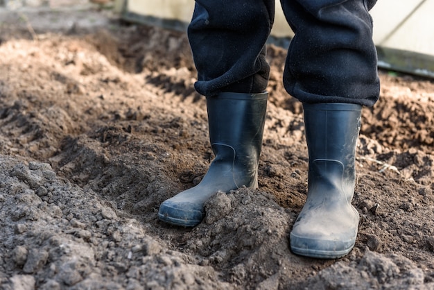 Uomo in piedi con gli stivali sul suolo