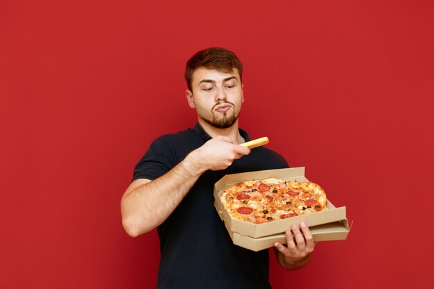 Uomo in piedi con la scatola della pizza in mano e fare foto