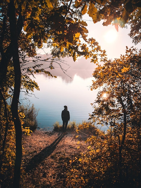 Uomo in piedi davanti al lago