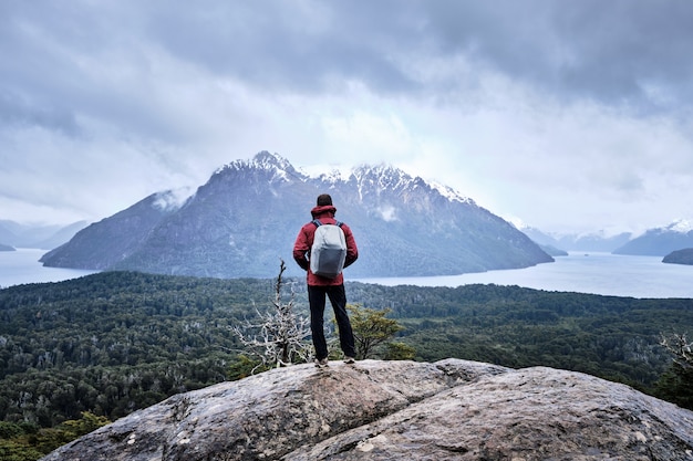 Uomo in piedi su una roccia in montagna