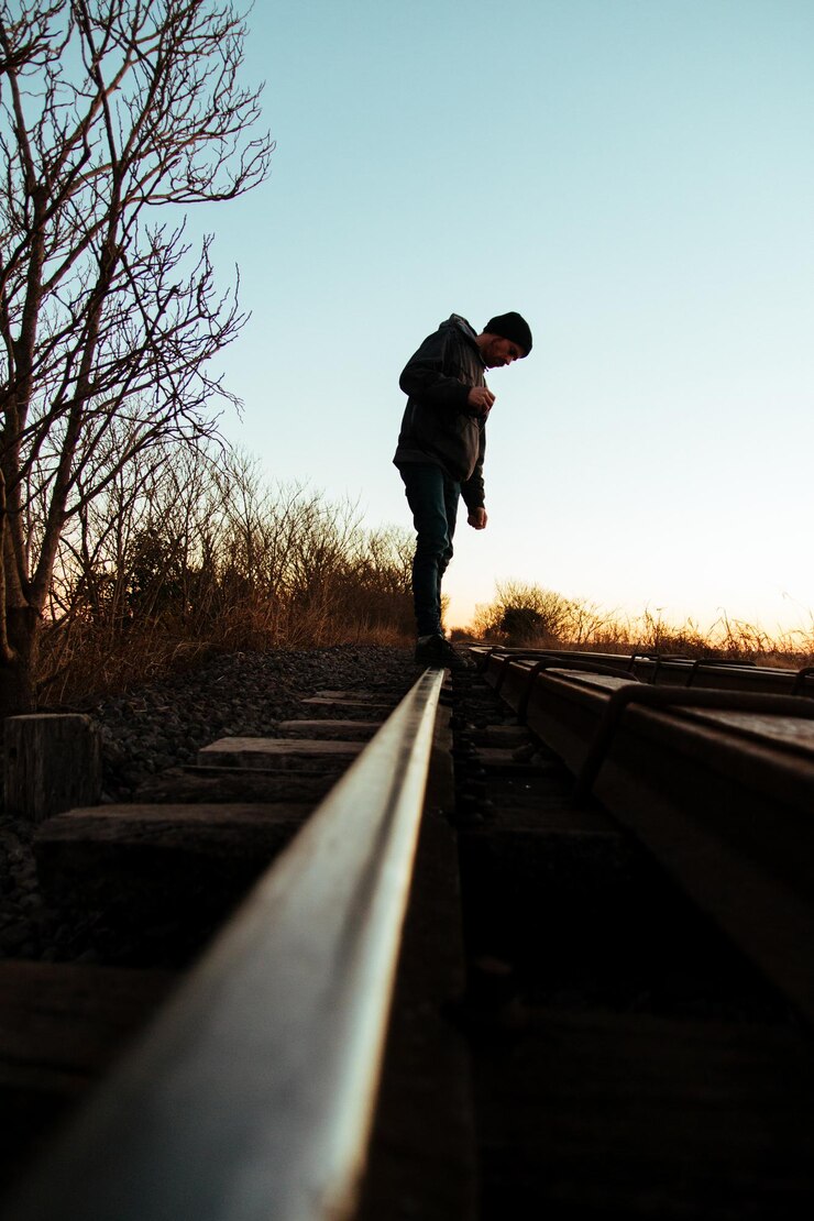 Foto uomo in piedi sui binari del treno