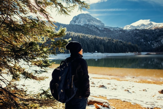 Uomo in piedi sul campo vicino al lago durante l'inverno