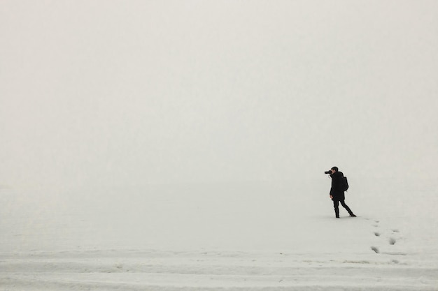 Uomo in piedi sul ghiaccio nebbioso mattino semplice fotografia minimalista una persona