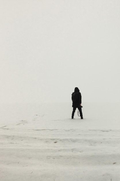 Uomo in piedi sul ghiaccio nebbioso mattino semplice fotografia minimalista una persona