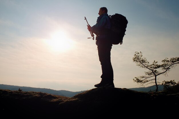 Uomo in piedi sulla montagna contro il cielo durante il tramonto