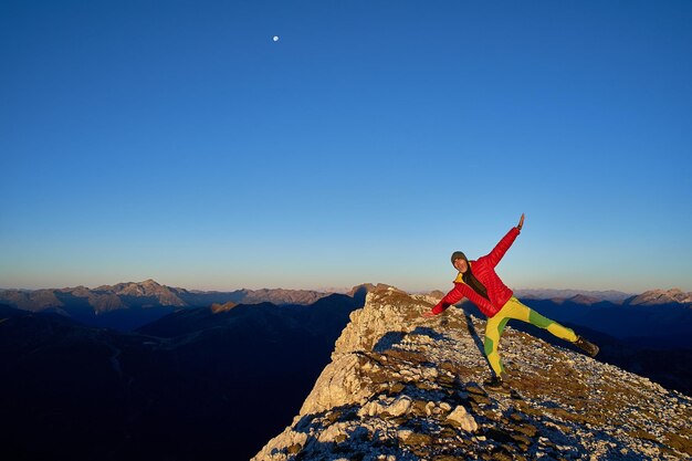 Uomo in piedi sulla montagna contro un cielo blu limpido