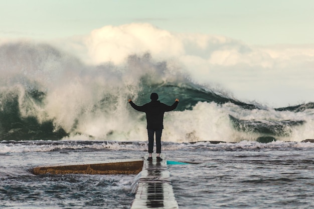 Uomo in piedi sulla riva del mare contro il cielo