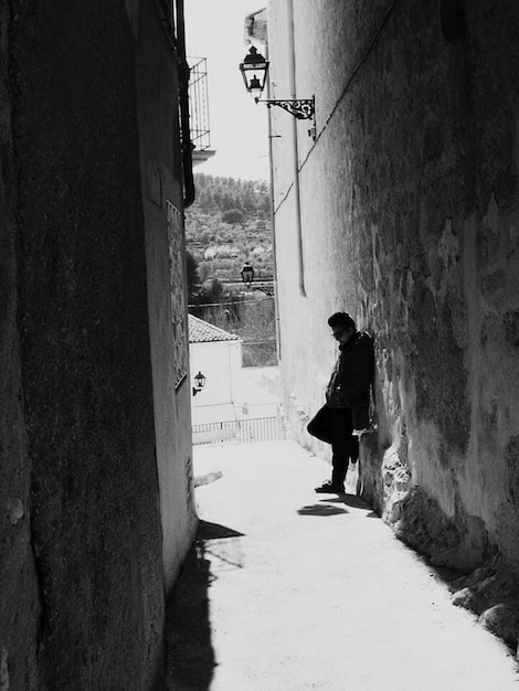 Uomo in piedi sulla strada tra gli edifici