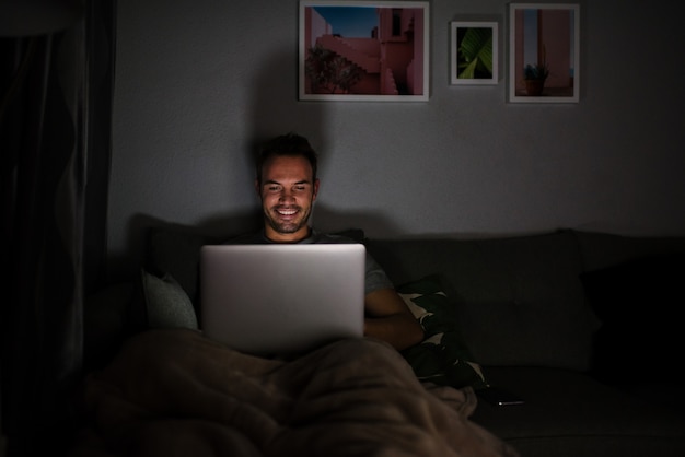 Uomo in pigiama con un computer