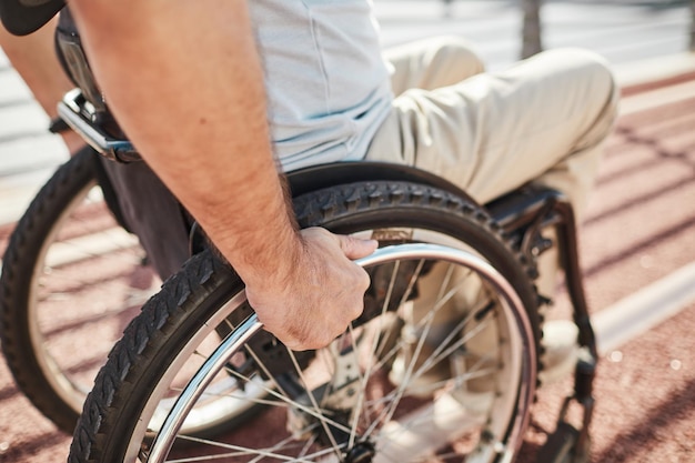 Uomo in sedia a rotelle all'aperto da vicino