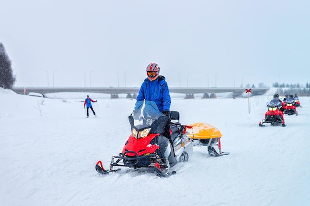 Uomo in sella a una motoslitta sul lago ghiacciato in inverno Rovaniemi, Lapponia, Finlandia