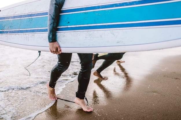 Uomo in spiaggia con la sua tavola da surf