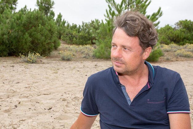 Uomo in spiaggia di sole rilassante contro una splendida vista sul mare