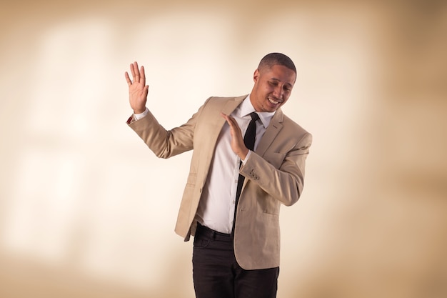 Uomo in tailleur beige in studio fotografico su uno sfondo con luci.