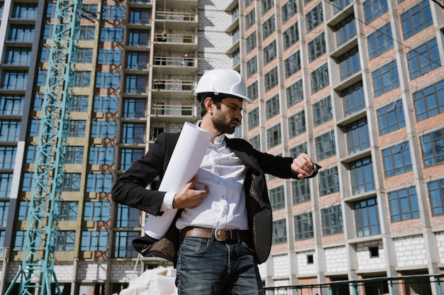 Uomo in tuta e casco con blueprint