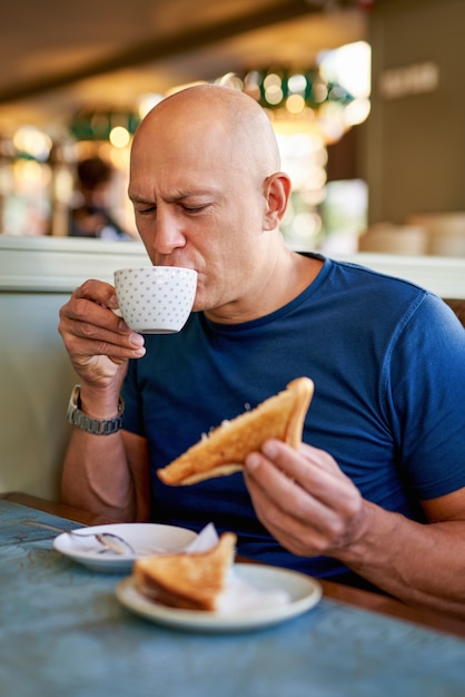 Uomo in un caffè a colazione